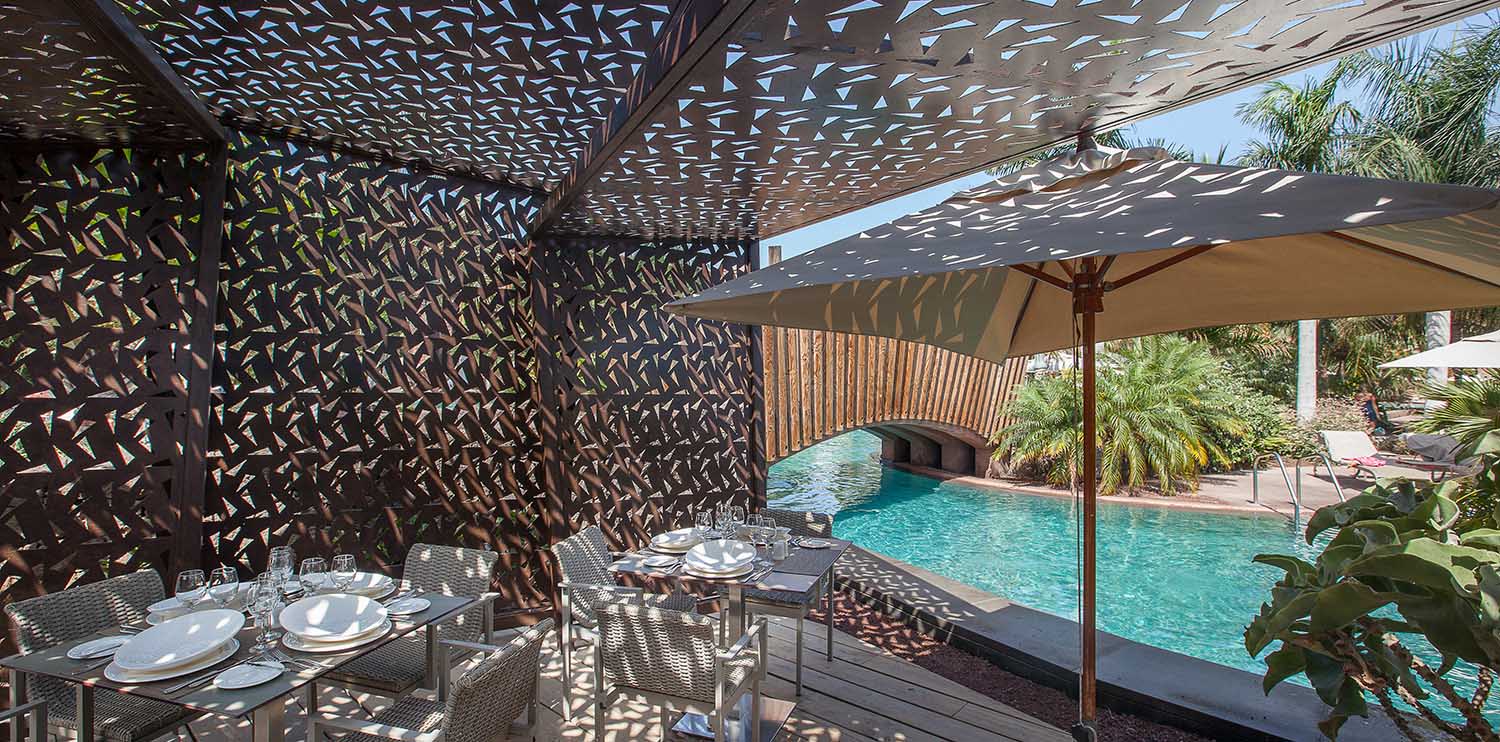 	Terrace of the Pili Pili restaurant at the hotel Lopesan Baobab Resort next to the slow river pool 	